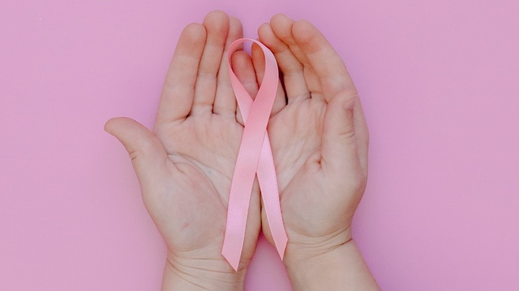 Pink ribbon on top of a hand | Breast Cancer Car Donations