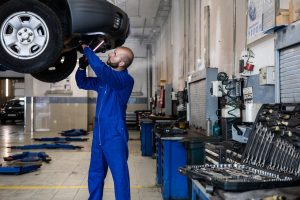 A Man in Blue Suit Checking a Car | Breast Cancer Car Donations