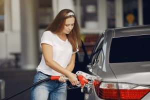 Focused young woman refueling car | Breast Cancer Car Donations