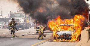 Firemen try to put out the fire on a car | Breast Cancer Car Donations