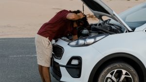 Man fixing his car on the road | Breast Cancer Car Donations